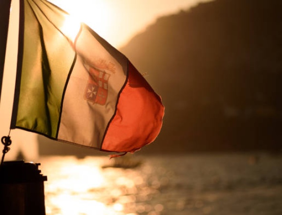 Sunset through Italian Naval flag on sailboat off the coast of Capri